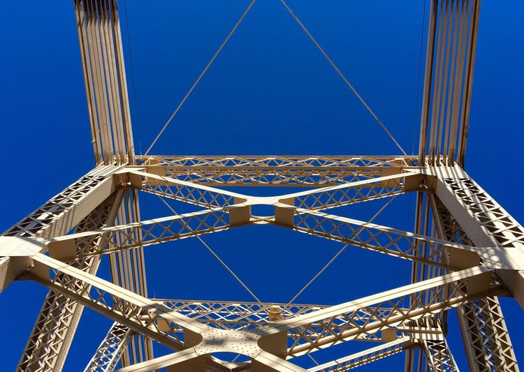 Low angle view of metallic structure at queensboro bridge against clear blue sky