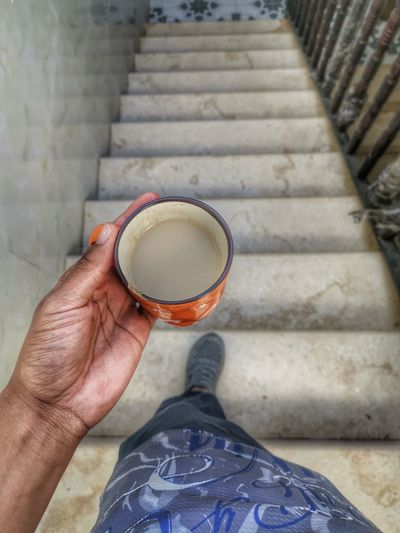 Low section of person holding coffee cup