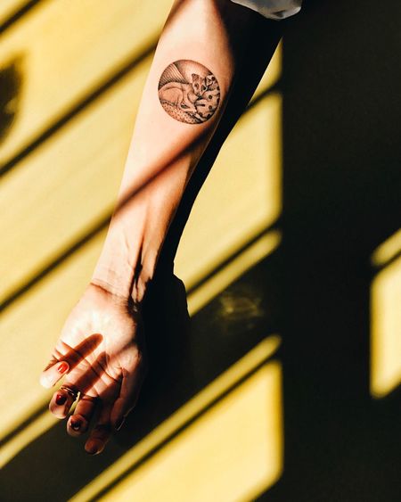 Low section of woman with tattoo on hand