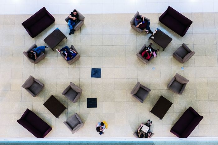 High angle view of people sitting on armchairs in building