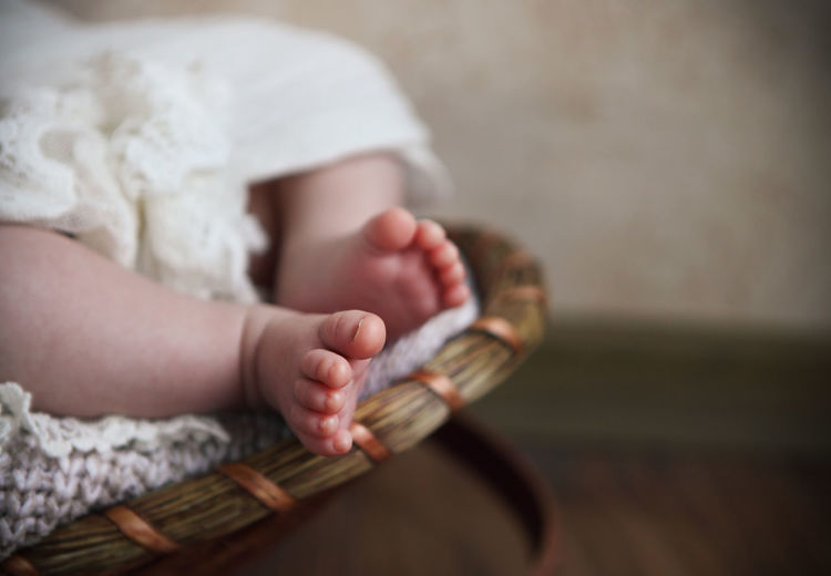 Low section of baby relaxing in basket