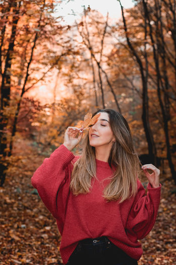 Portrait of beautiful young woman standing on land during autumn