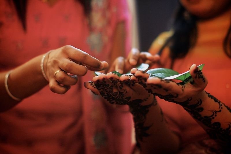 Midsection of woman performing henna tattoo rituals
