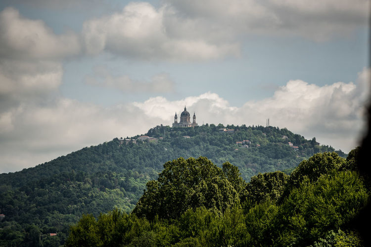Panoramic view of trees and buildings against sky. the hill of superga with the church in turin