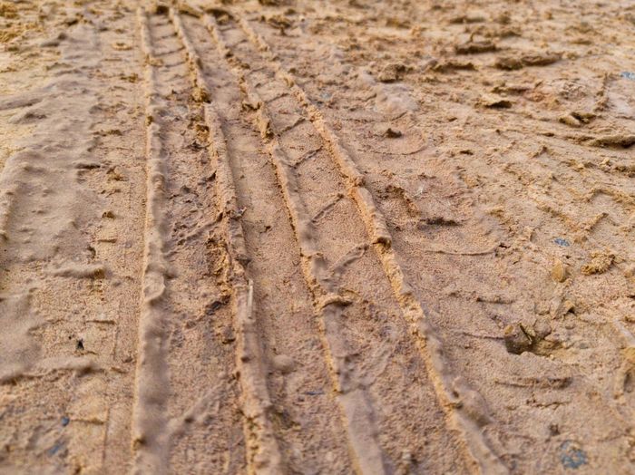 Close-up of tire tracks on sand