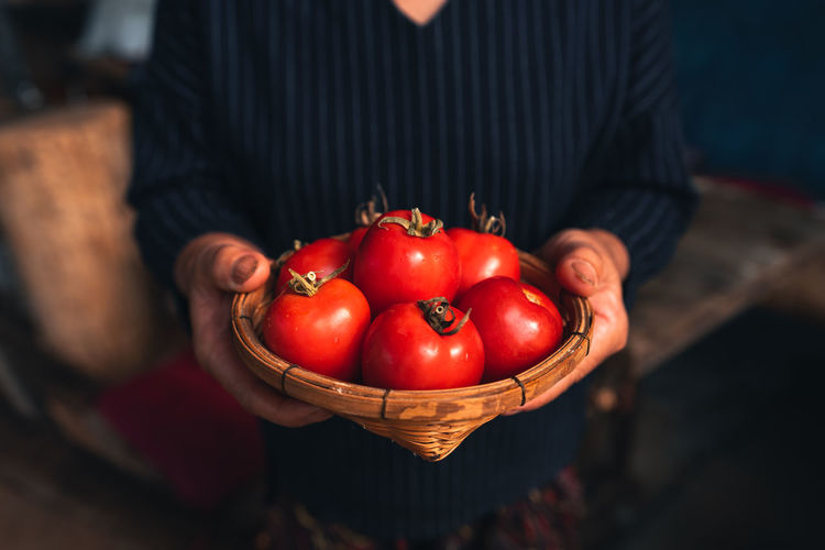 Man holding red chili peppers in basket