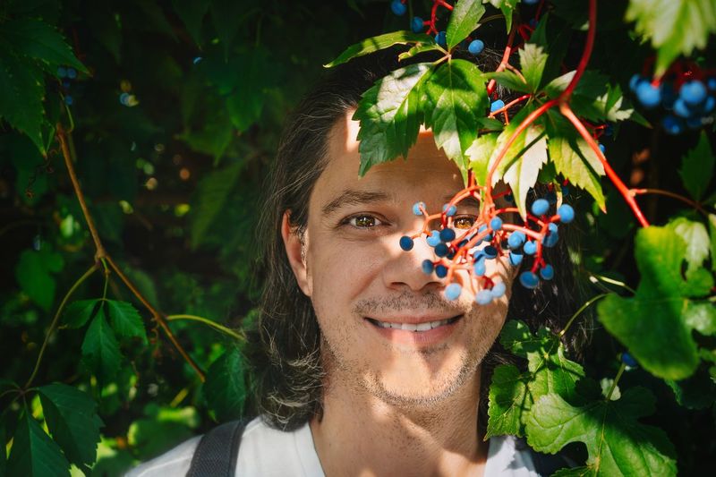 Portrait of smiling man with ivy fruits in autumn