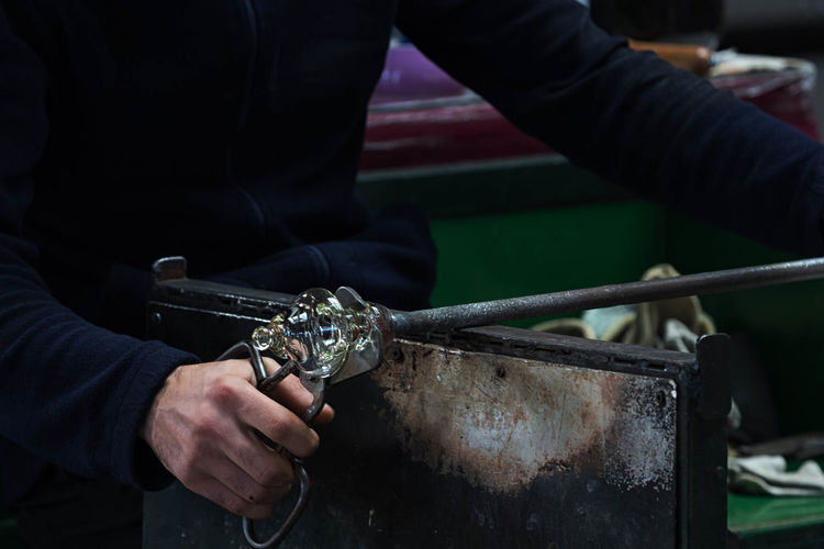 Cropped image of hand holding machine part