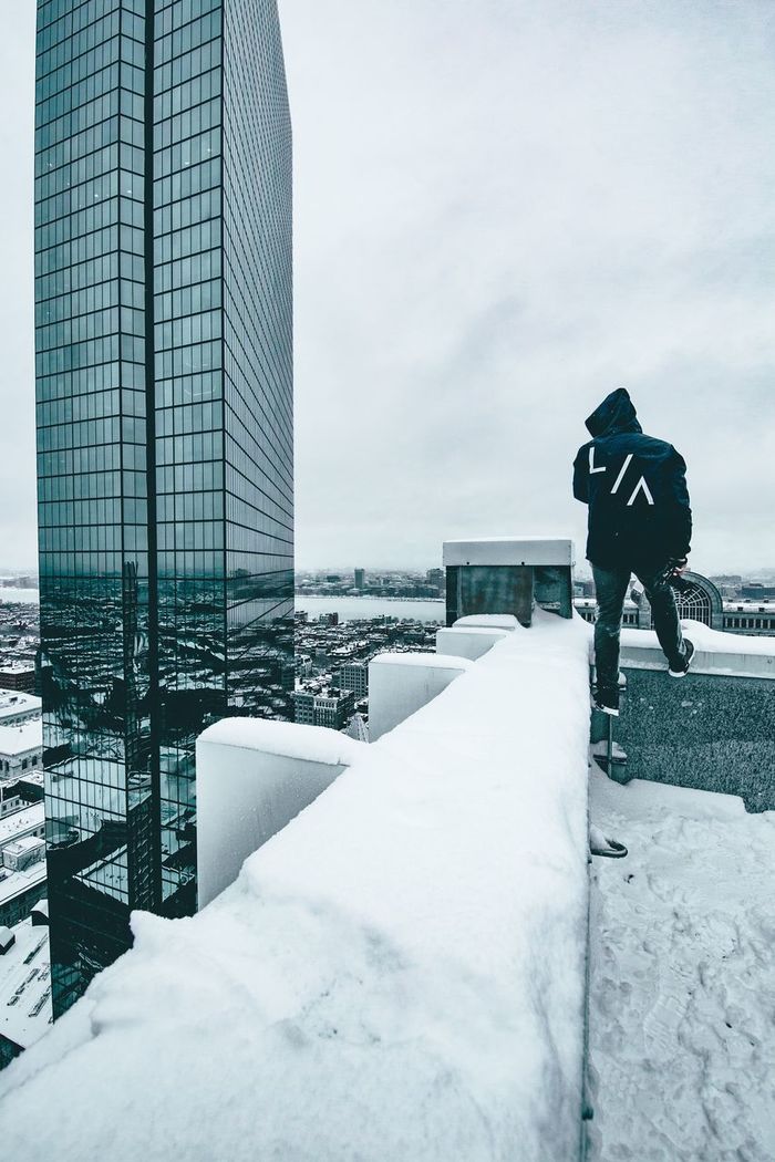 MAN STANDING ON SNOW COVERED CITY