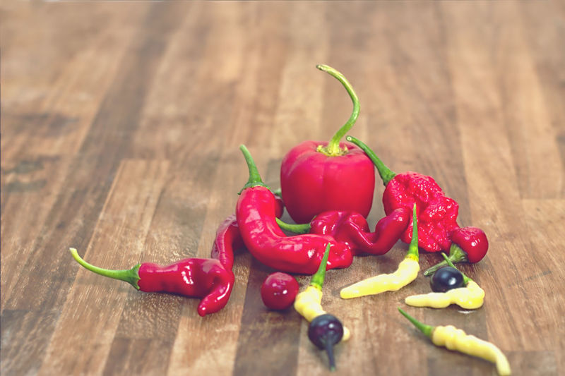Close-up of colorful peppers on wooden surface