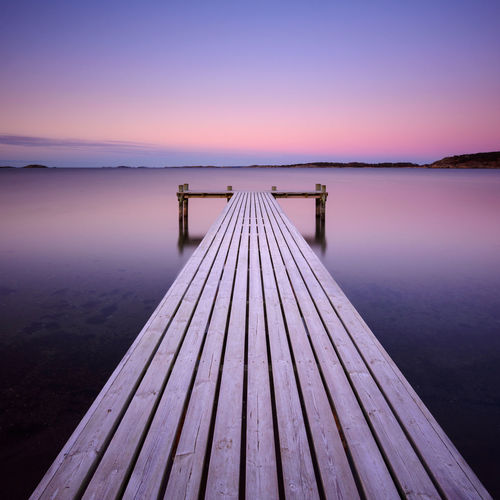 Wooden frosty jetty leading into the sea, sweden.
