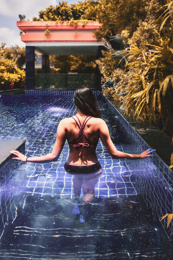 Rear view of woman in swimming pool
