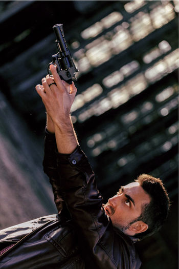 Tilt image of man aiming handgun