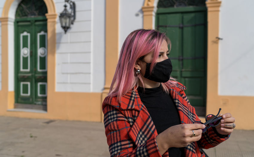 Woman with foot mask standing on a scenic sidewalk in the city