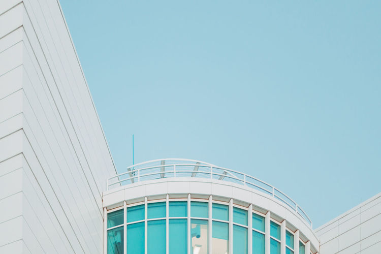 Low angle view of modern building against clear blue sky