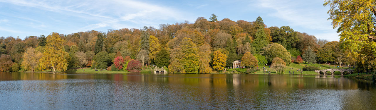 Panoramic photo of the autumn colours around the lake at stourhead gardens in wiltshire.