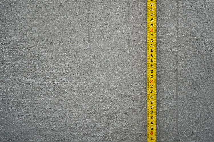 Measure tape against gray wall
