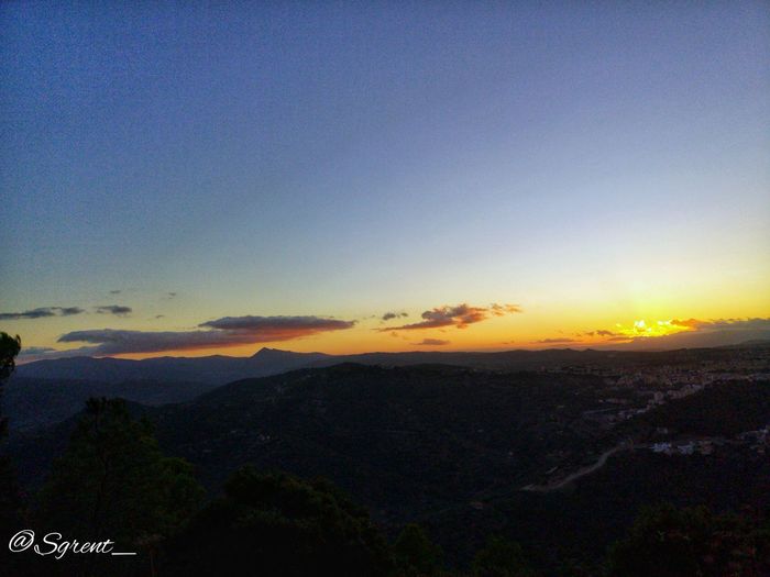 Scenic view of silhouette mountains against sky at sunset