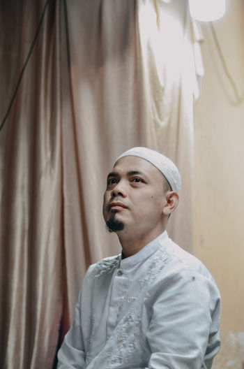 Man wearing skull cap while looking away