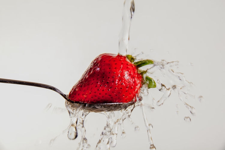 Close-up of strawberry in water against white background