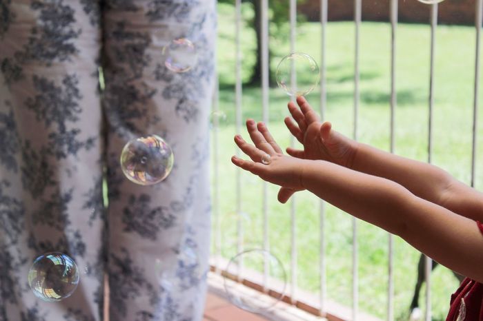 Kid hands with bubbles in balcony