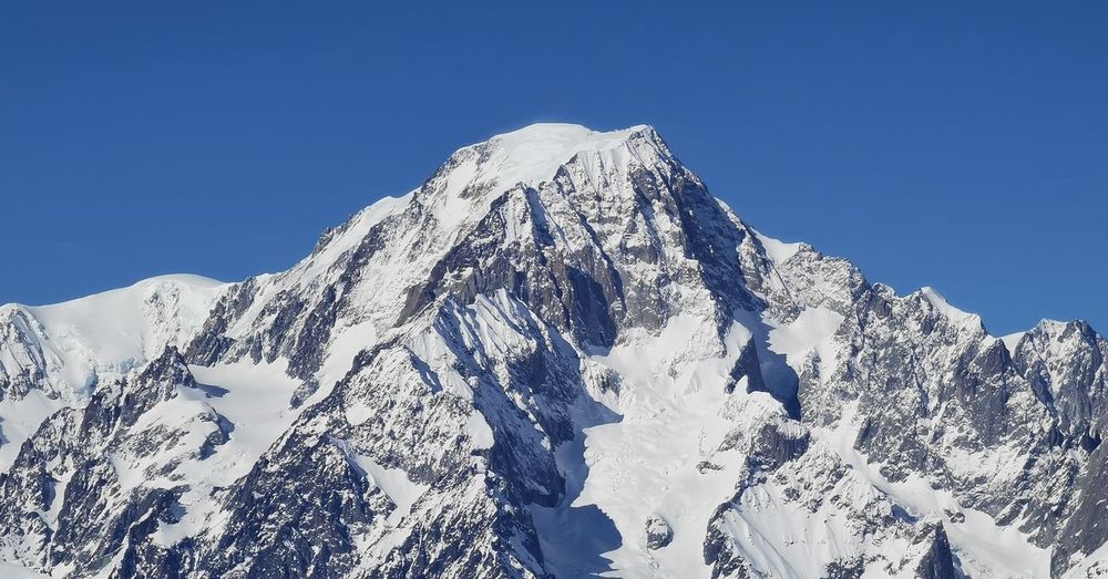Scenic view of snowcapped mountains against clear blue sky
