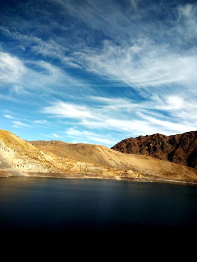 Scenic view of lake by mountains against sky