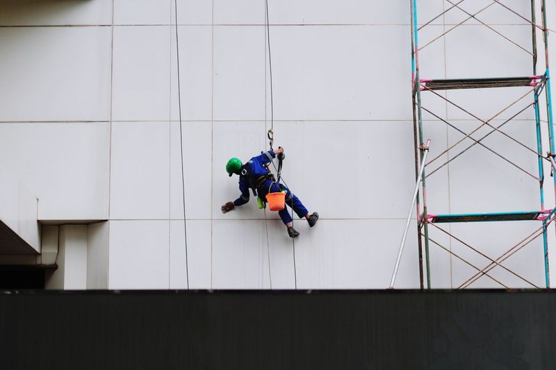 Man working on rope against building