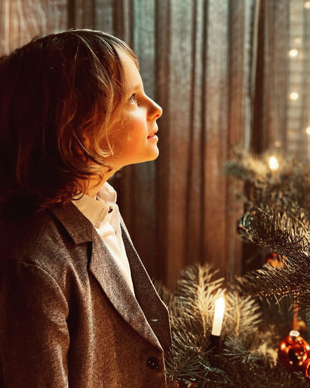 Close-up of young woman blowing christmas tree