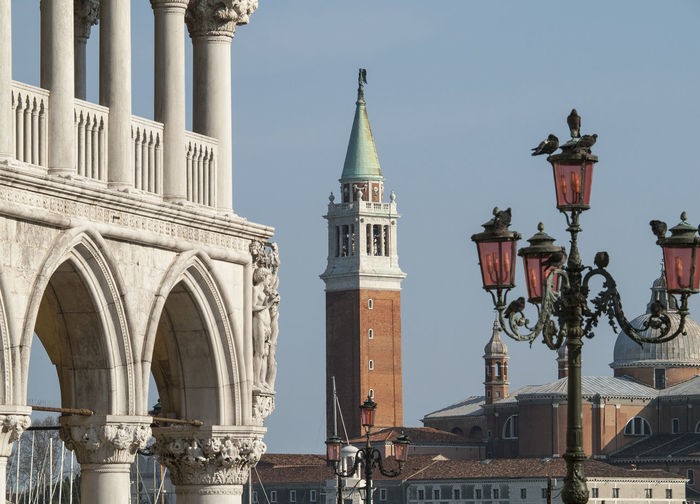 Antique street light with san marco campanile against clear sky