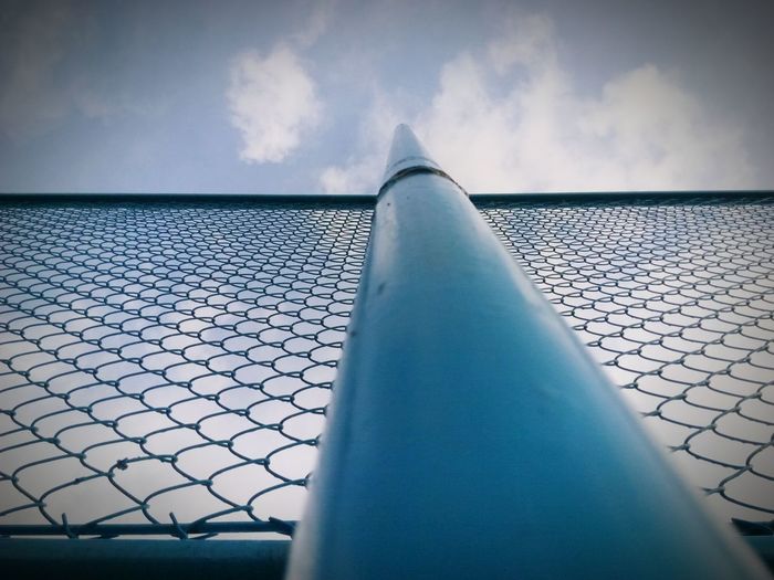 Low angle view of pole and chainlink fence