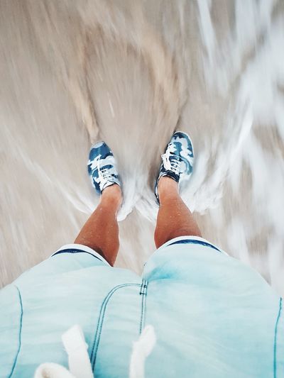 Low section of man standing in sea