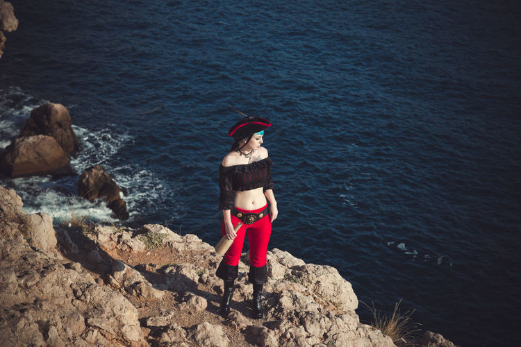 Portrait of a pirate woman at the beach. in anticipation of a pirate ship