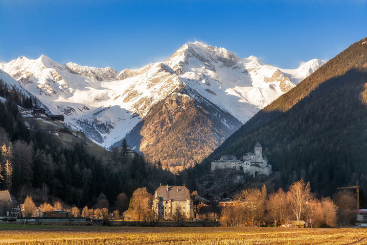 Landscape of campo tures town with castle taufers and the snowcapped aurine alps on the background