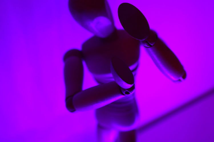 High angle view of wooden figurine against purple wall