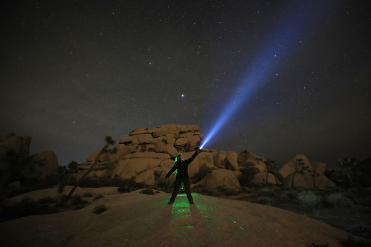 Man standing on mountain against sky at night
