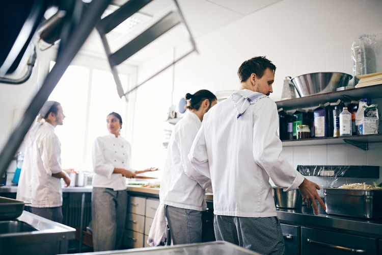 Chefs preparing food at counter in commercial kitchen