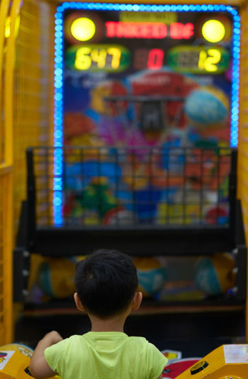 Rear view of boy playing indoors