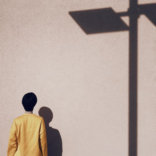 Rear view of man standing against wall