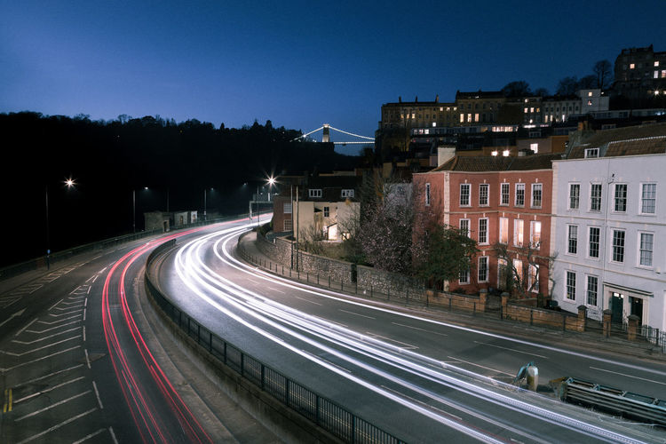Light trails on road against sky at night