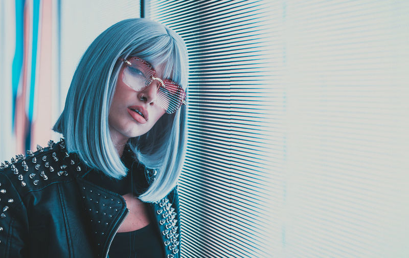 Portrait of young woman standing against abstract backgrounds