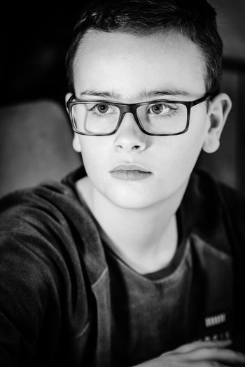 Close-up of boy wearing eyeglasses looking away