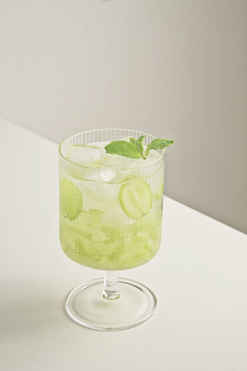 Green drink on table against white background