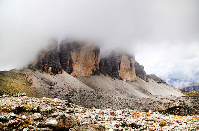 Scenic view of dolomites against cloudy sky