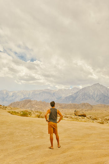 Young man in the california desert looking mountains of alabama hills.