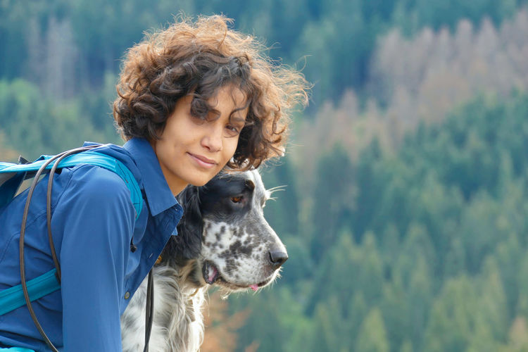 Portrait of a young woman and a dog hiking in the mountains of harz, germany