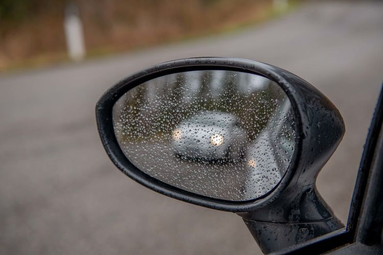 Close-up of wet side-view mirror
