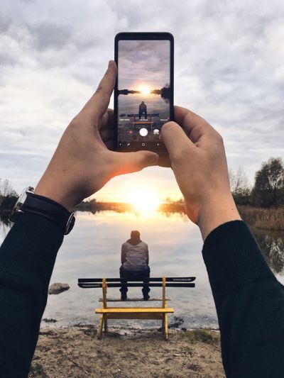 Midsection of man using mobile phone at beach