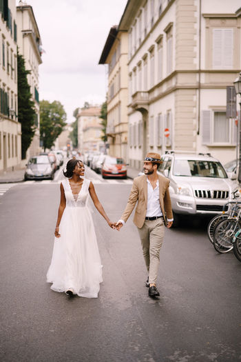 Couple holding hand walking on street