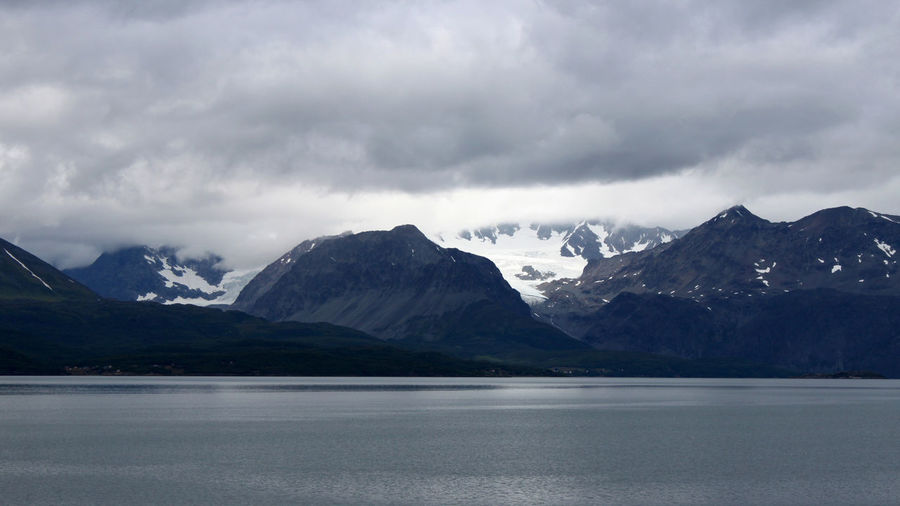 Scenic view of mountains and lake against cloudy sky